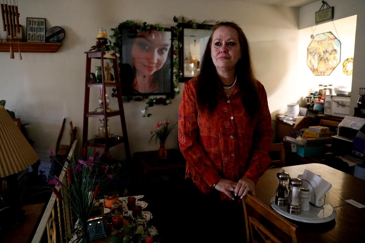 Melinda Bettencourt sits by a photo of her daughter, Amanda Bews