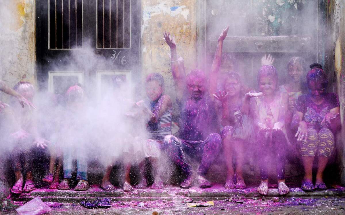 Indian children throw colored powder in the air during Holi festival celebrations in Chennai, India.