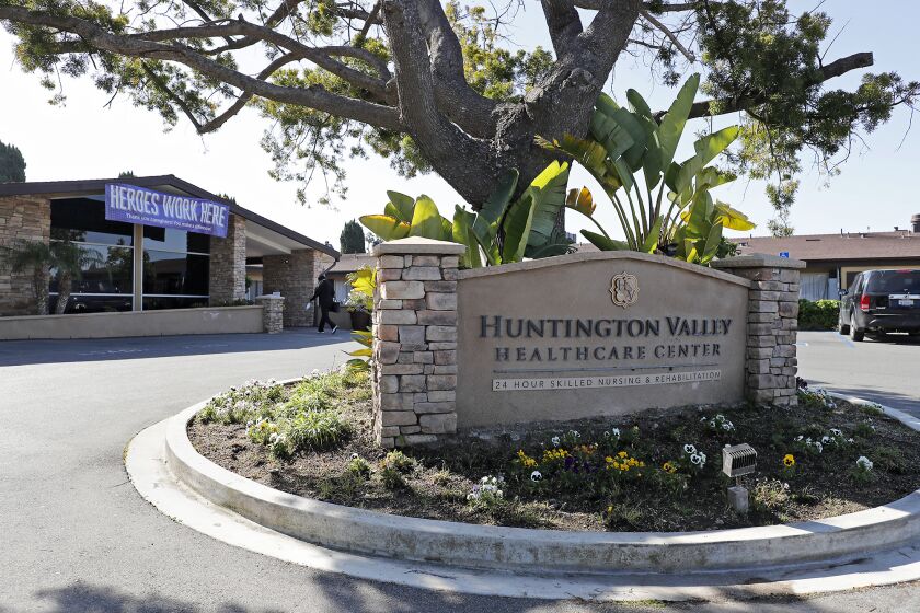 A healthcare worker enters the Huntington Valley Healthcare Center in Huntington Beach on Wednesday, April 22. This facility had its first two deaths Tuesday related to the coronavirus pandemic; more than 70 additional staff and residents have been infected.