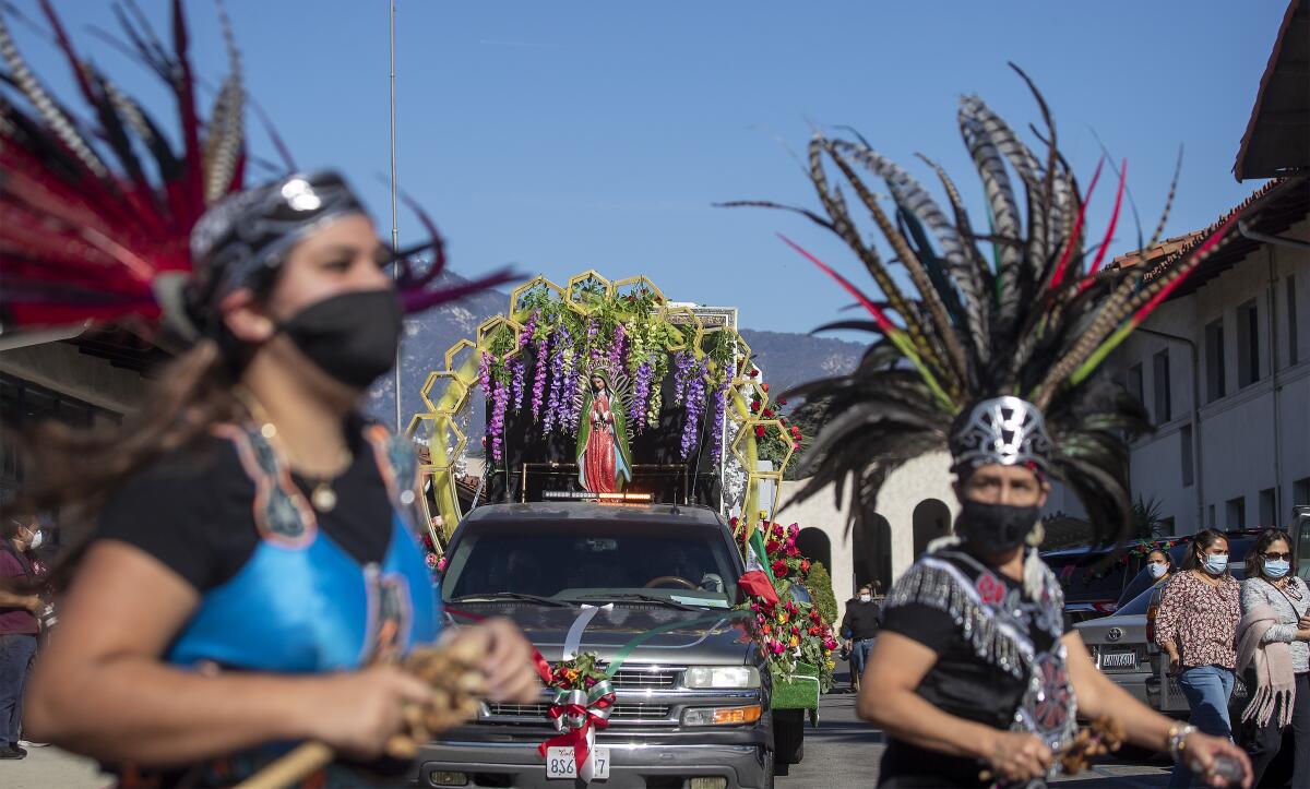 Dancers lead Sunday's procession, which featured fewer participants due to the pandemic.