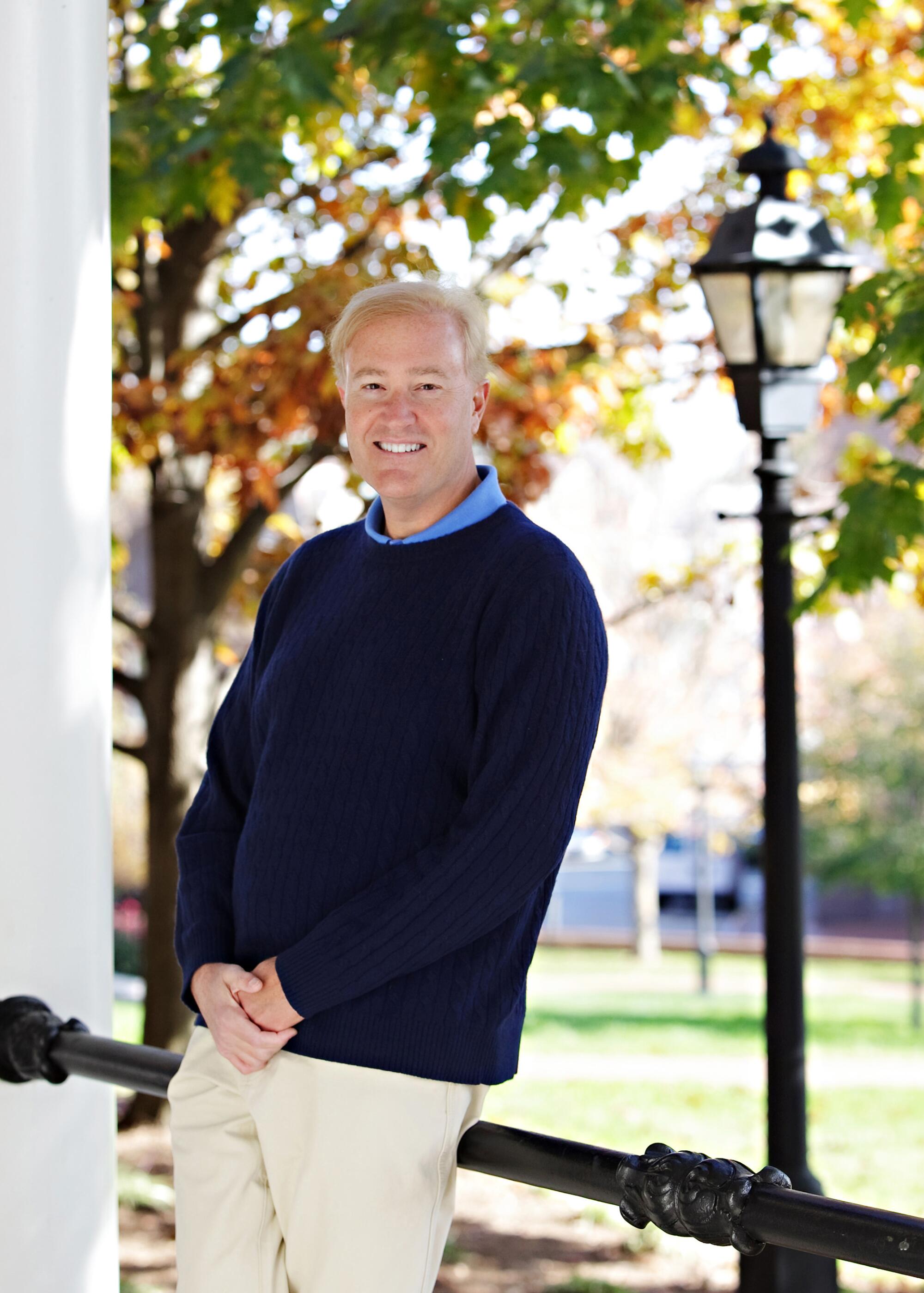 Brian VanDeMark poses outdoors near trees.