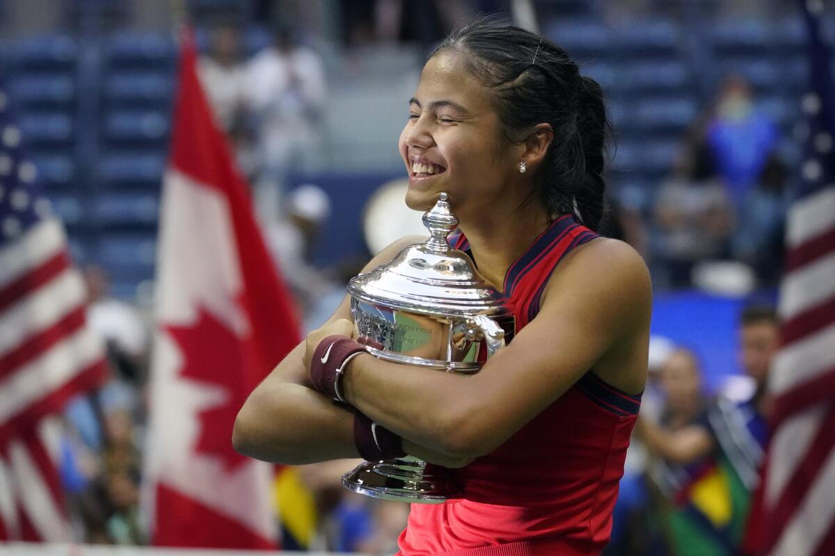 Emma Raducanu, of Britain, hugs the US Open championship trophy after defeating Leylah Fernandez, of Canada, during the women's singles final of the US Open tennis championships, Saturday, Sept. 11, 2021, in New York. (AP Photo/Elise Amendola)