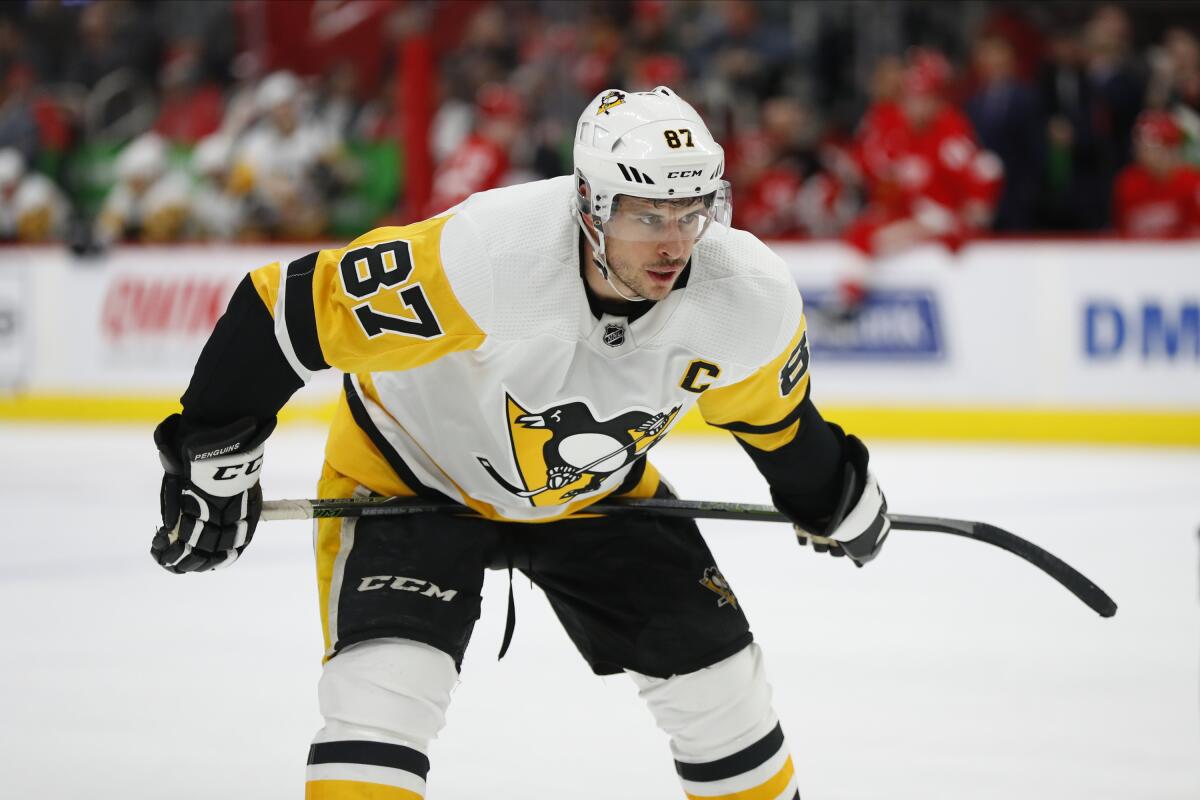 Sidney Crosby, on the ice, bent at the waist and holding his stick horizontally.
