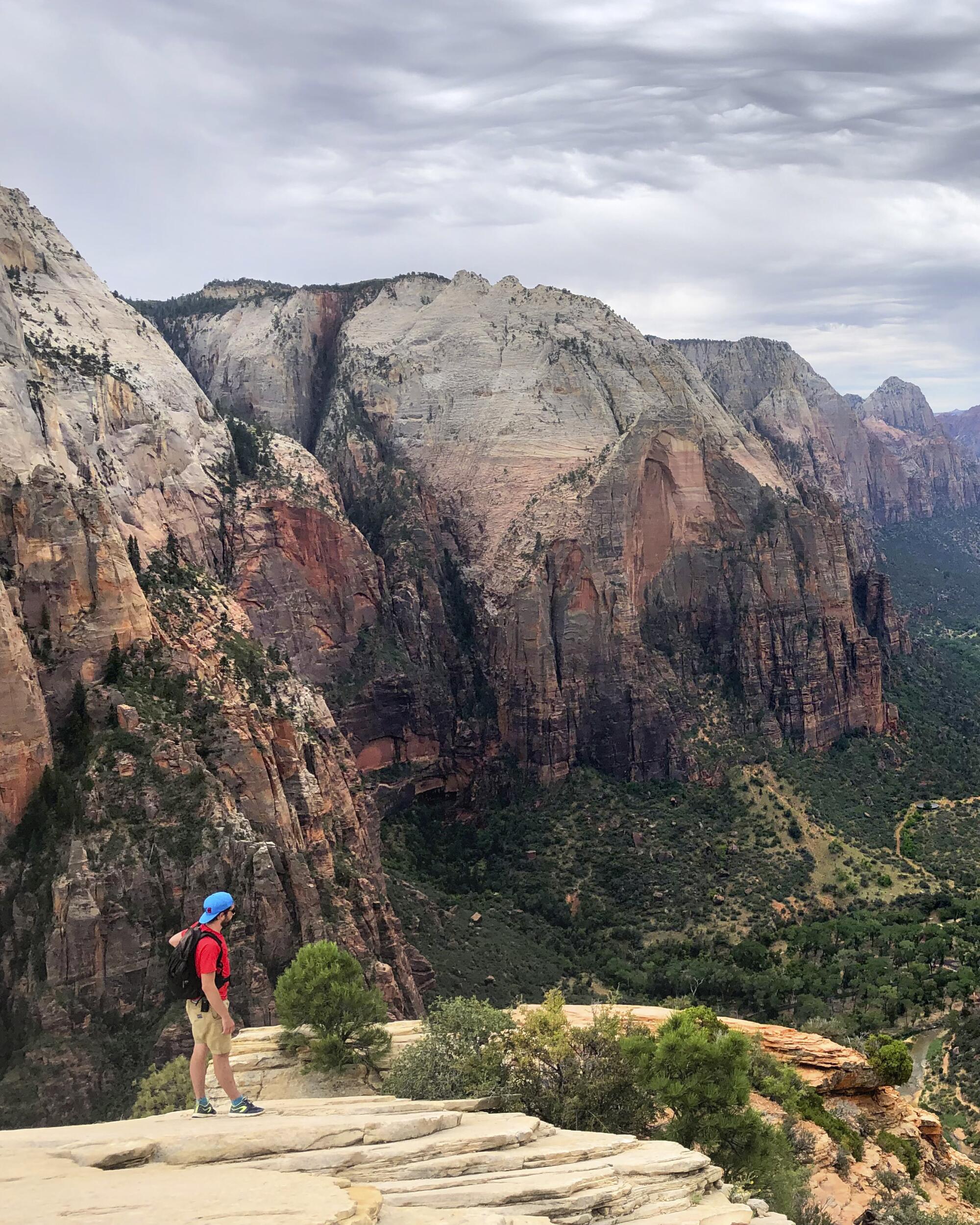 A hiker takes in the view from the top of Angels Landing in Zion National Park. 
