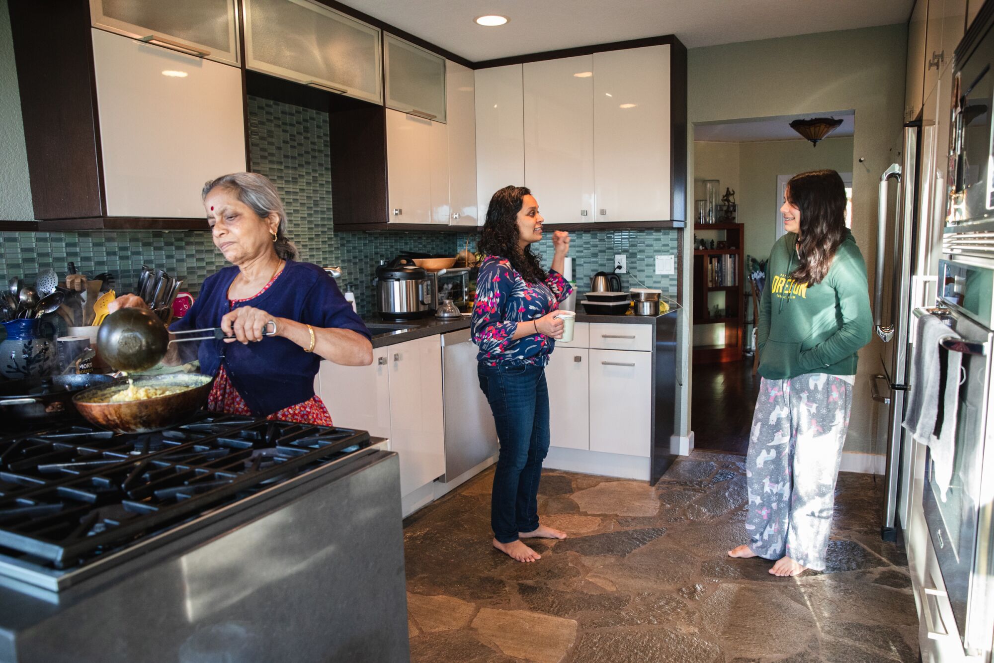 Prasannakshi Karnamadakala cooks breakfast as Deepti Wilkinson and Vishaala Wilkison talk
