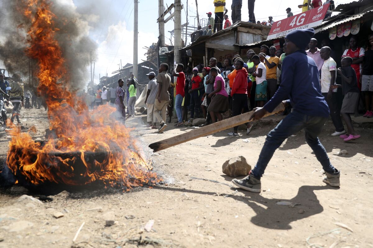 A protestor burns tyres to block the road on the outskirts of Nairobi, Thursday, March 30, 2023. Police in Kenya are on high alert ahead of the third round of anti-government protests organized by the opposition that has been termed as illegal by the government. (AP Photo/Brian Inganga)
