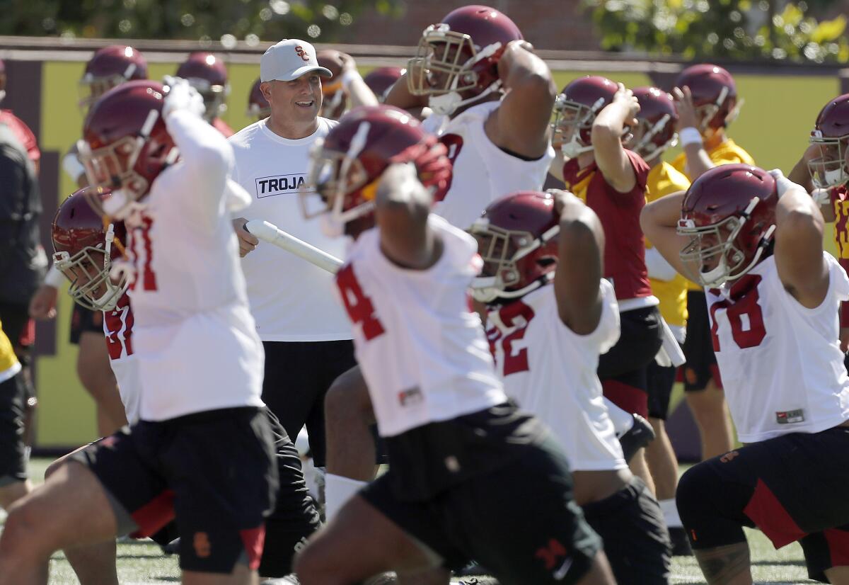USC football coach Clay Helton runs players through warm-ups during the opening of training camp at USC.