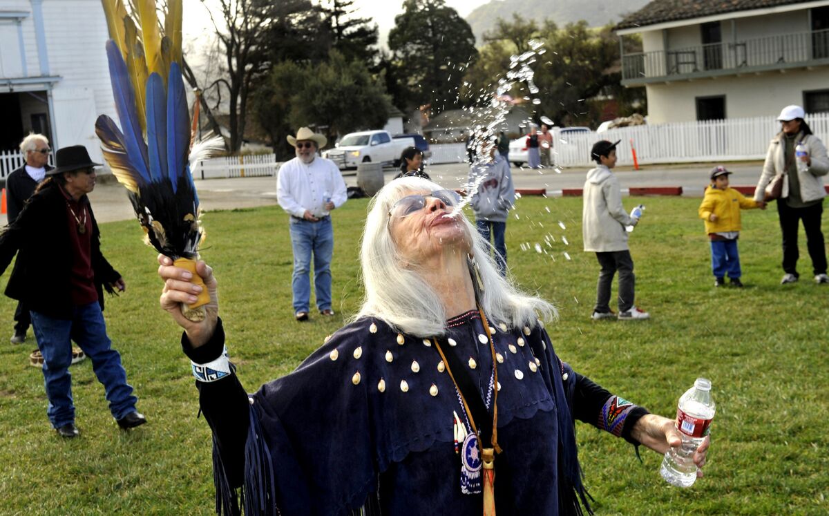 Laynee Reyna spits water during a rain dance in San Juan Bautista on a recent Sunday. ¿Water attracts water,¿ she said.
