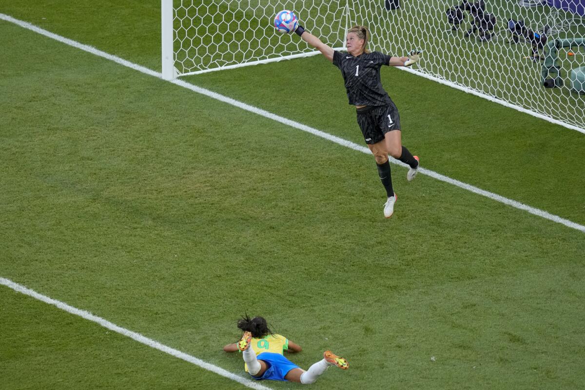 U.S. goalkeeper Alyssa Naeher saves a header by Brazil's Adriana during the Americans' gold-medal match win