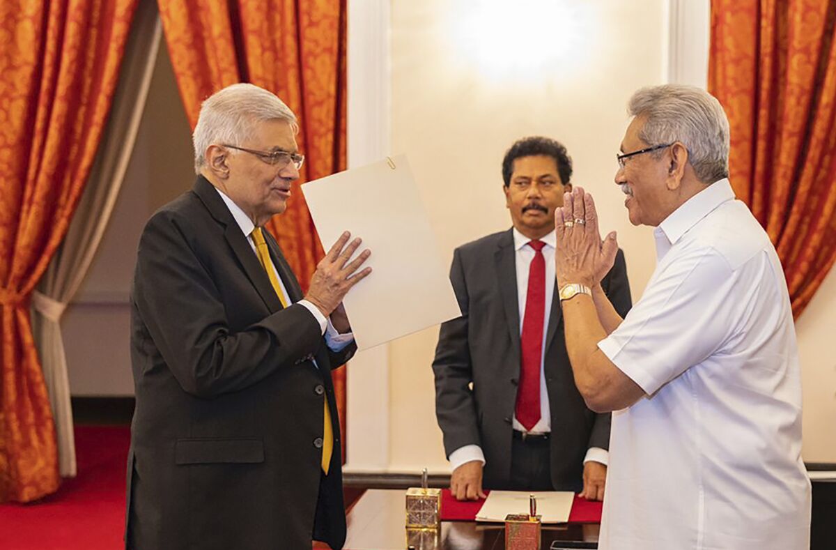 In this handout photograph provided by the Sri Lankan President's Office, President Gotabaya Rajapaksa, right, greets Ranil Wickremesinghe during the latter's oath taking ceremony as the new prime minister in Colombo, Sri Lanka, Thursday, May 12, 2022. Wickremesinghe has been reappointed in an effort to bring stability to the island nation engulfed in a political and economic crisis. (Sri Lankan President's Office via AP)