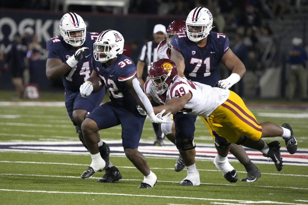 Arizona running back DJ Williams runs away from USC defensive lineman Tuli Tuipulotu.