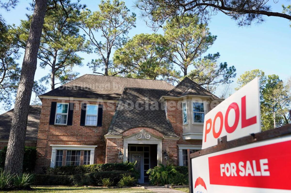 A real estate sign is shown at a home for sale in Houston.