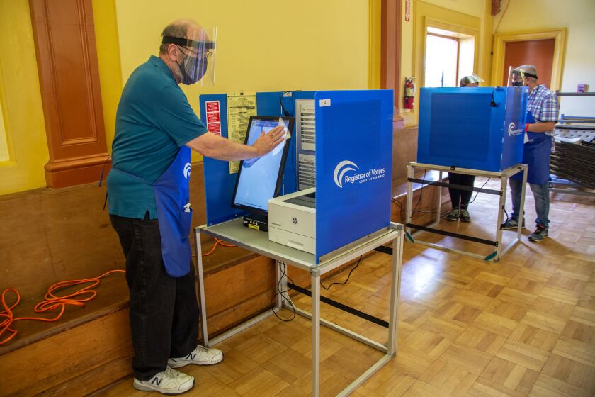 SAN DIEGO, CA - NOVEMBER 03: Peter Volkert sanitizes electronic polling stations after each use on Tuesday, Nov. 3, 2020 in San Diego, CA. (Jarrod Valliere / The San Diego Union-Tribune)