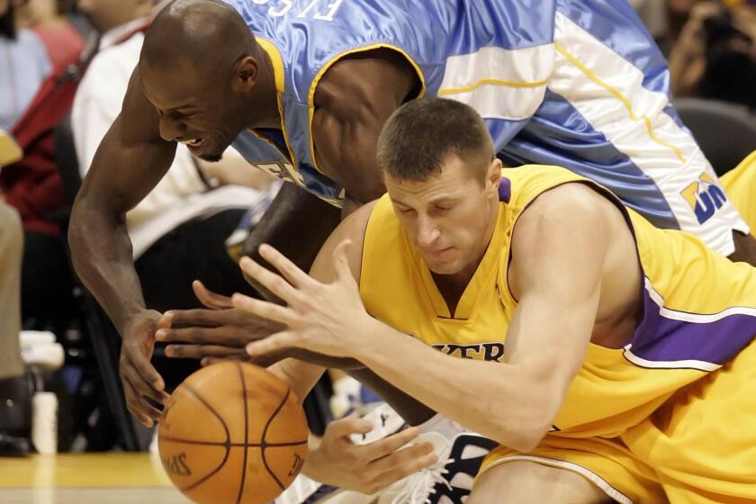 FILE - Los Angeles Lakers' Slava Medvedenko, right, of Ukraine, and Denver Nuggets' Francisco Elson, top, of the Netherlands, dive for the ball in the first quarter of a preseason NBA basketball game in Los Angeles, Oct. 20, 2005. Former Lakers player Medvedenko is selling his two NBA championship rings to raise money for his native Ukraine. (AP Photo/ Francis Specker, File)