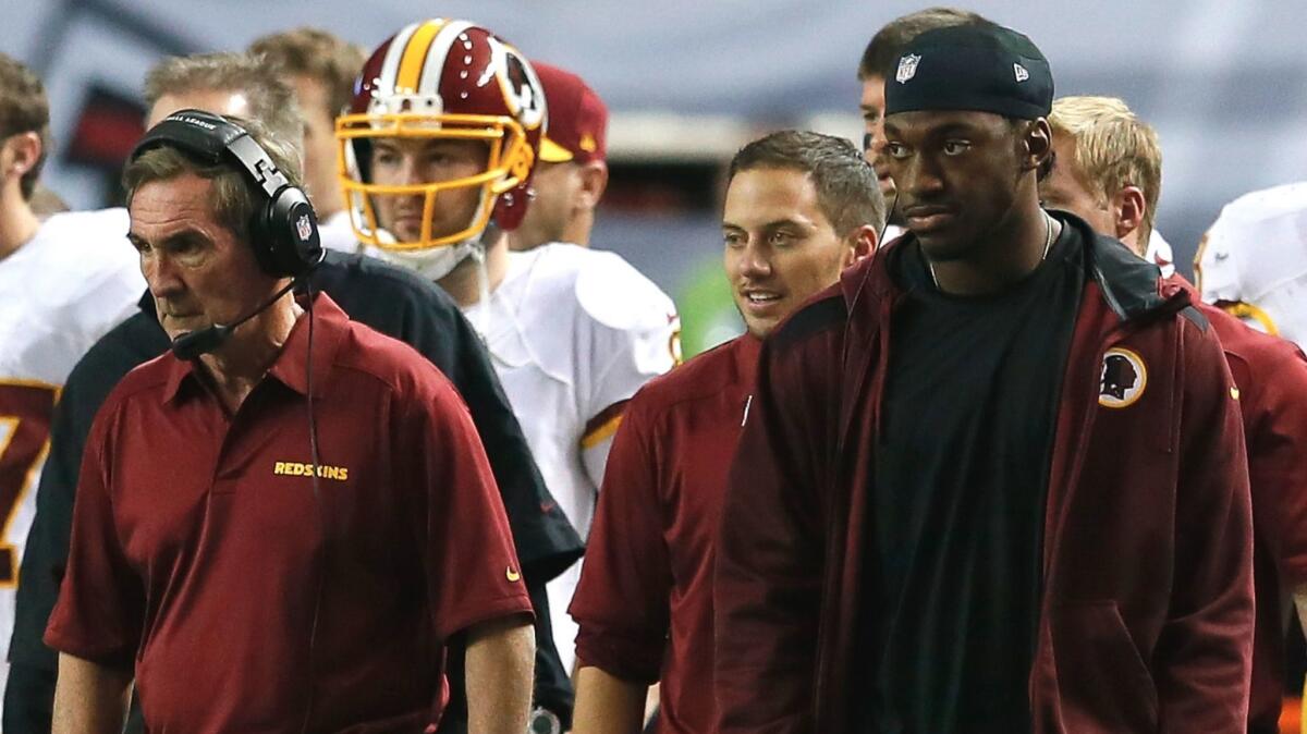 Mike Shanahan, left, and Robert Griffin III watch from the Washington Redskins' sideline on Dec. 15, 2013.