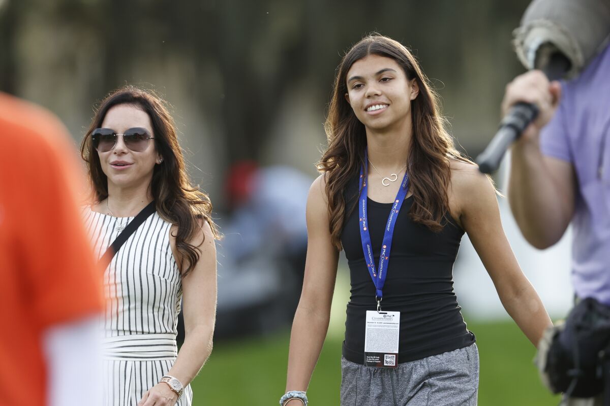 FILE - Sam Alexis Woods, right, daughter of Tiger Woods, walks with Wood's girlfriend Erica Herman during the first round of the PNC Championship golf tournament Saturday, Dec. 18, 2021, in Orlando, Fla. Woods has asked his daughter to introduce him for his induction to the World Golf Hall of Fame. (AP Photo/Scott Audette, File)