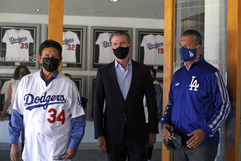 Los Angeles, California-Oct. 30, 2020-Gov. Gavin Newsom, center, visits Dodger Stadium with former Dodger pitcher Fernando Valenzuela, left, and CA Secretary of State Alex Padilla, right, on Oct. 30, 2020. (Carolyn Cole/ Los Angeles Times)