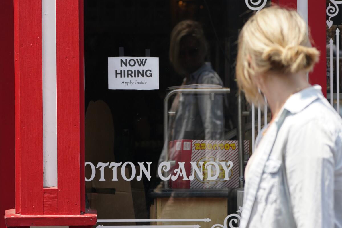 A sign for a job opening is posted in the window of a business in Monterey.