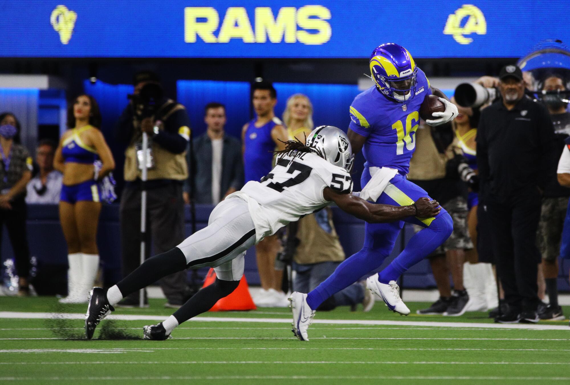 Rams quarterback Bryce Perkins scampers for extra yardage before being tackled by Raiders linebacker Asmar Bilal.
