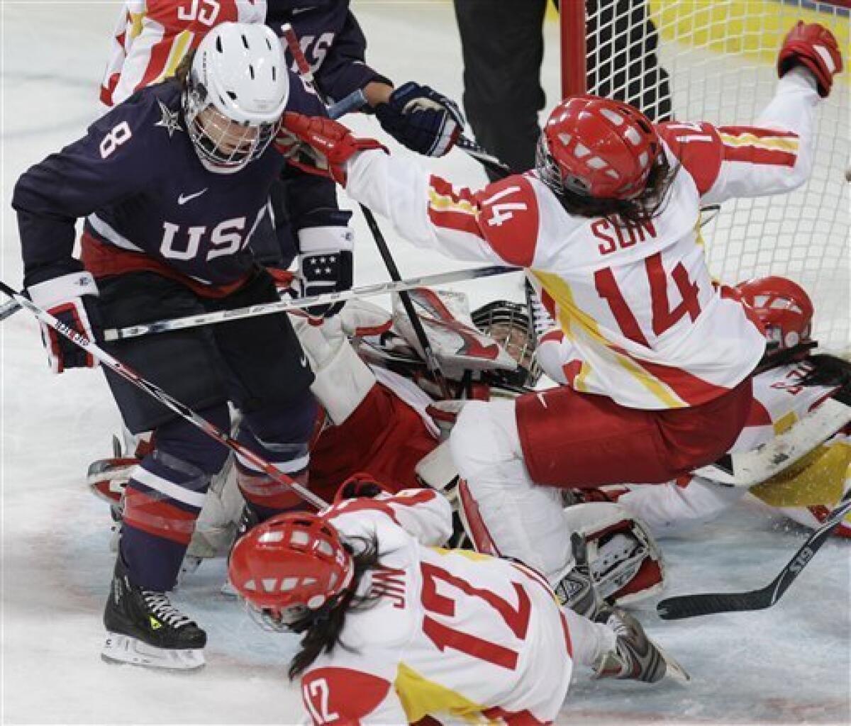 USA's defenseman Caitlin Cahow (8) tussles with China's forward Sun Rui and Jin Fengling (12) in the second period in women's preliminary round hockey play at the Vancouver 2010 Olympics in Vancouver, British Columbia, Sunday, Feb. 14, 2010. (AP Photo/Chris O'Meara)