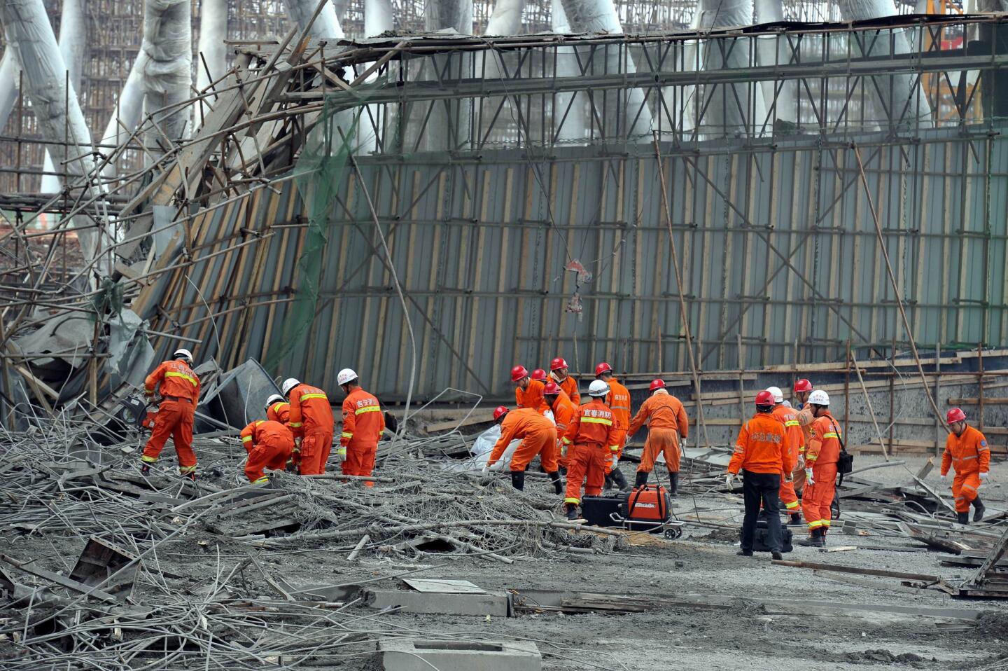 Workers search for survivors in the debris of a collapsed platform in a power station cooling tower in Fengcheng, in China's Jiangxi province.