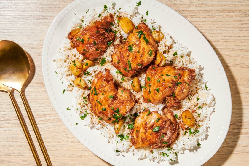 Chicken thighs rest on top of a bed of rice.