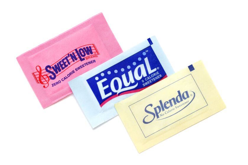 Product shot of three different brands of zero calorie sweeteners: Sweet N Low in pink, Equal in blue, and Splenda in yellow.