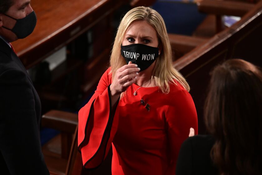 Rep. Marjorie Taylor Greene, R-Ga., wears a "Trump Won" face mask as she arrives on the floor of the House to take her oath of office on opening day of the 117th Congress at the U.S. Capitol in Washington, Sunday, Jan. 3, 2021. (Erin Scott/Pool via AP)