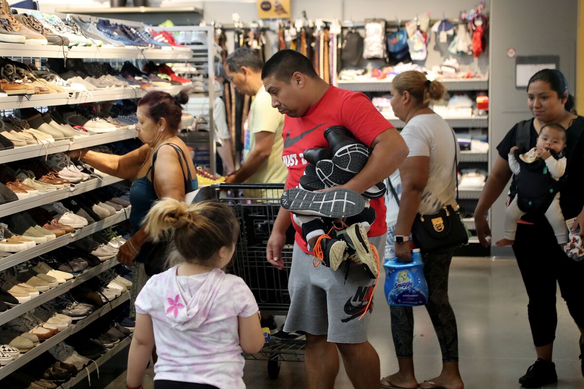 Shoppers browse through a shoe aisle at the newly reopened Goodwill Orange County in Santa Ana.