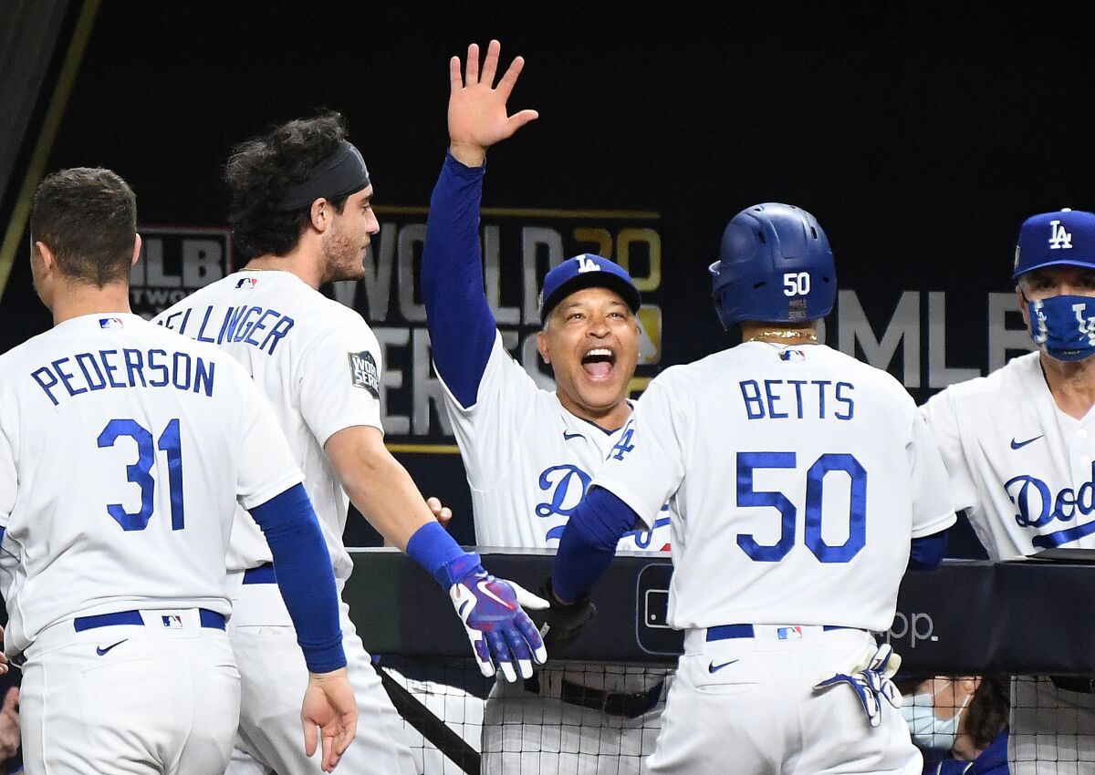 Dave Roberts celebrates with Mookie Betts after he scored a go-ahead run against the Rays in the 6th inning in Game 6