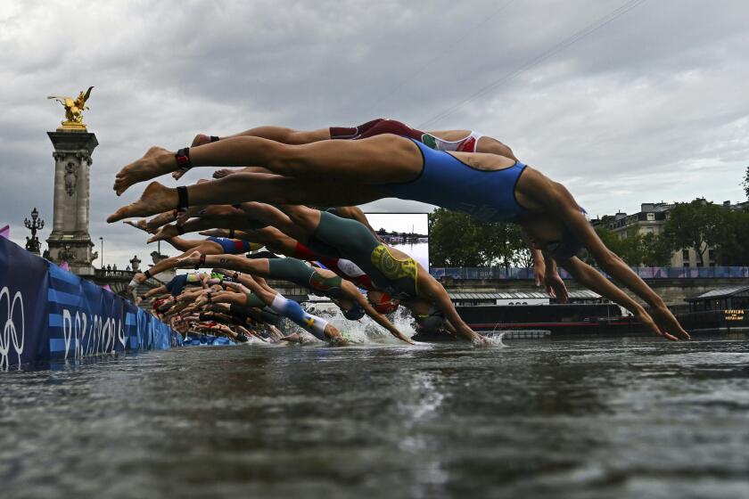 Athletes compete in the swimming race in the Seine during the women's individual triathlon.