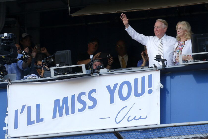 Dodgers announcer Vin Scully, with wife Sandi, waves to the fans after the team's 10th-inning victory over the Colorado Rockies on Sunday.