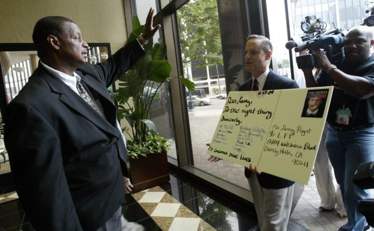 A San Francisco-based porn production company is accusing AIDS Healthcare Foundation President Michael Weinstein, seen here trying to deliver a note to Larry Flynt at his office in Beverly Hills regarding condoms on porn sets, of "fear-mongering" to push a political agenda.