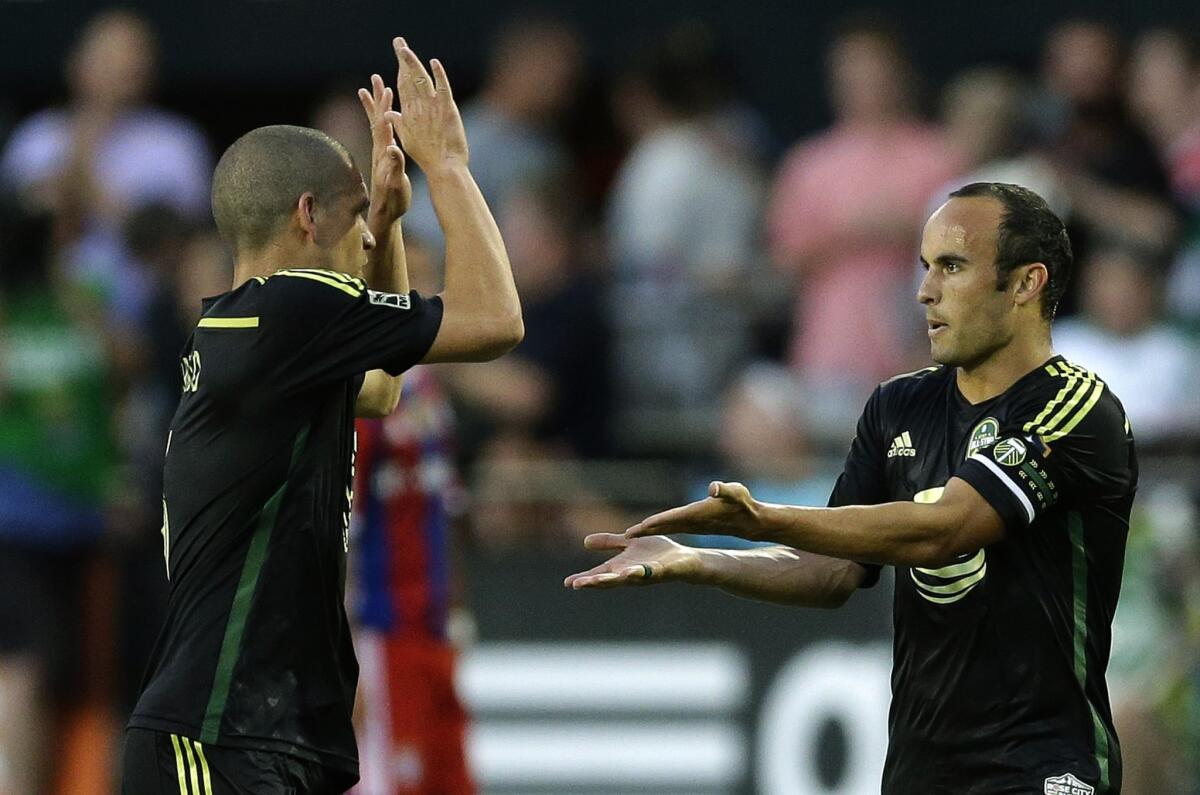 Galaxy forward Landon Donovan is greeted by Seattle midfielder Osvaldo Alonso after scoring a goal against Bayern Munich in the second half of the MLS All-Star match on Aug. 6.
