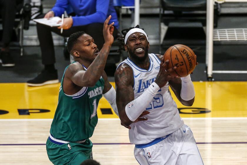 The Lakers' Montrezl Harrell drives to basket against the Dallas Mavericks' Dorian Finney-Smith on Dec. 25, 2020.