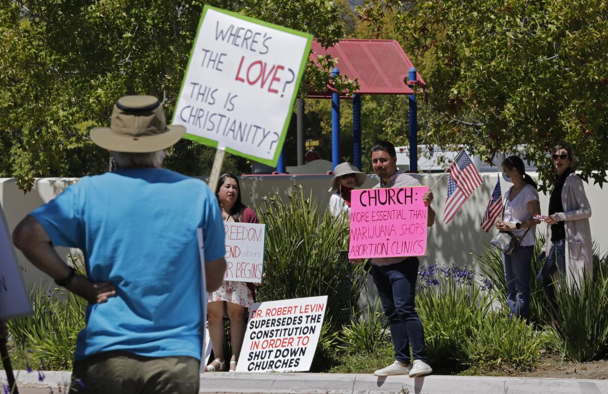 Supporters and protesters gather outside Godspeak Calvary Chapel, whose pastor defied a court order and held indoor services.