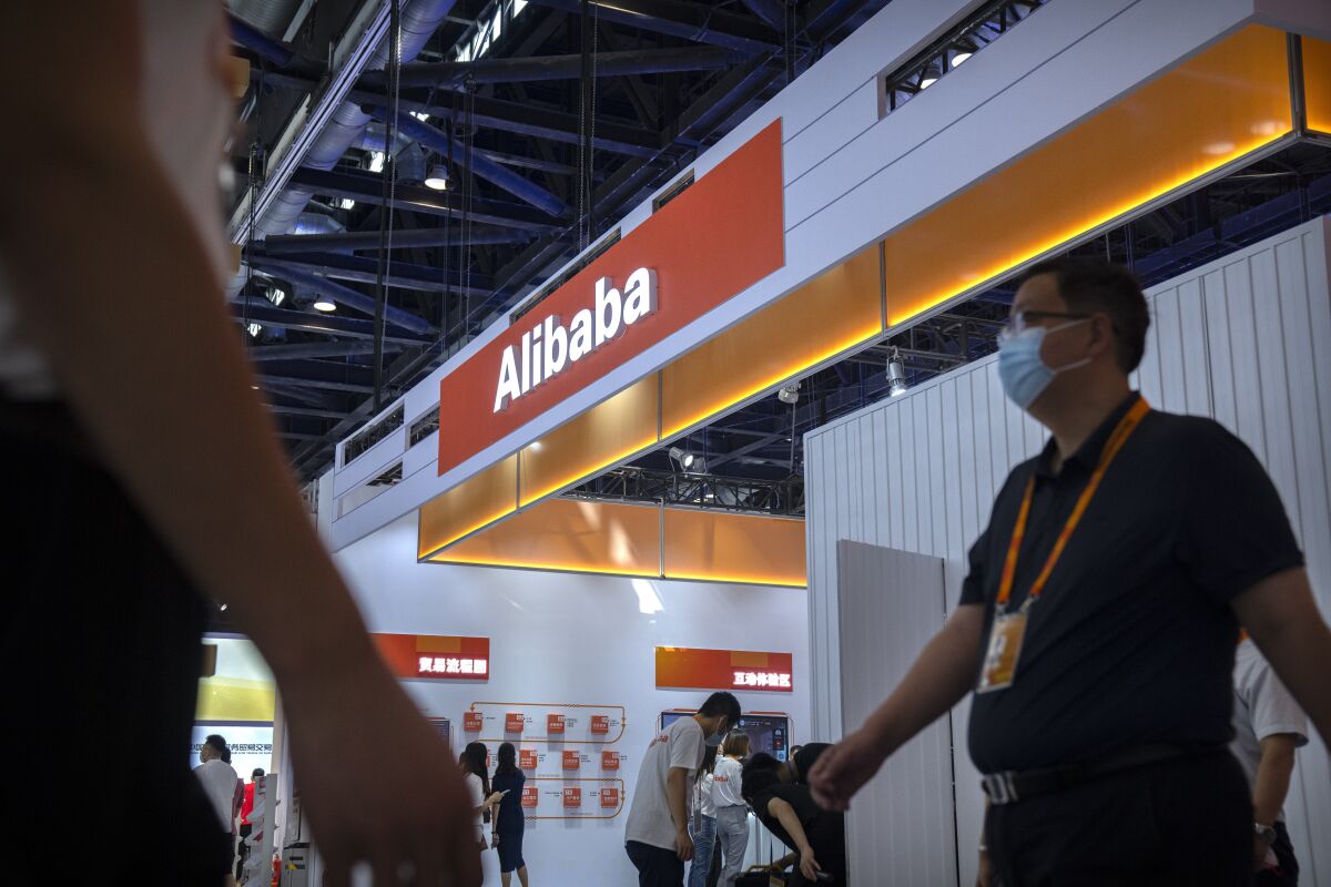 Visitors walk past a booth for Chinese technology firm Alibaba at the China International Fair for Trade in Services (CIFTIS) in Beijing, Friday, Sept. 3, 2021. E-commerce giant Alibaba Group said Friday it will spend $15.5 billion to support President Xi Jinping's campaign to spread China's prosperity more evenly, adding to pledges by tech companies that are under pressure to pay for the ruling Communist Party's political initiatives. (AP Photo/Mark Schiefelbein)