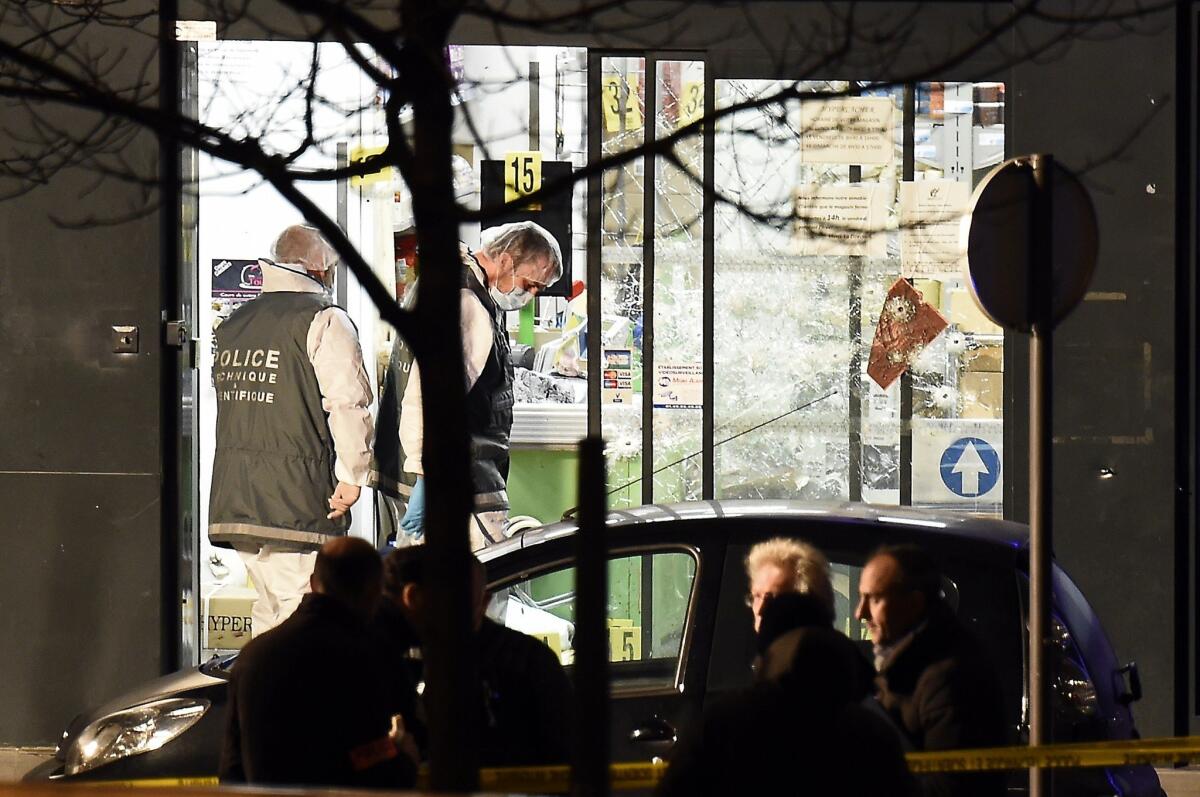 Forensic police investigate the scene at the kosher grocery store in southeastern Paris where gunmen held hostages until police launched an assault on Jan. 9.