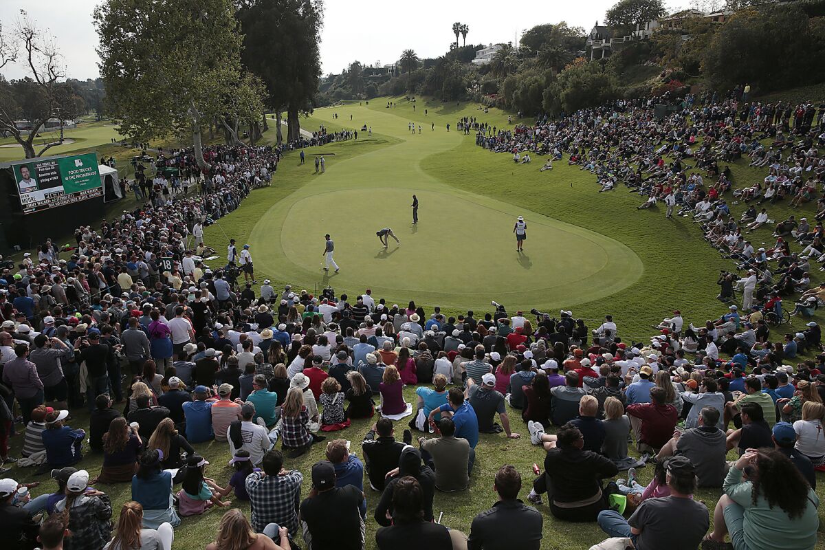 Spectators surround the 18th green during the Northern Trust Open golf tournament at Riviera Country Club. The first player under the PGA Tour umbrella has tested positive for the new coronavirus.