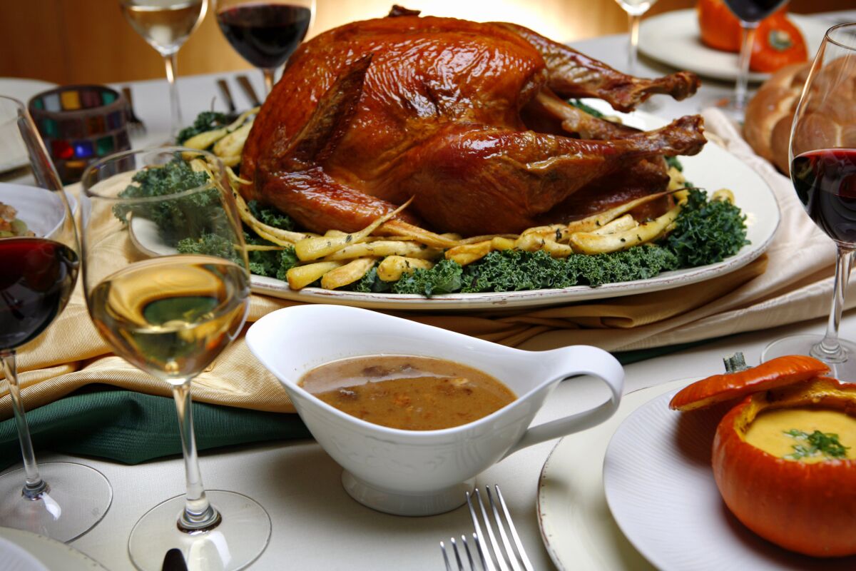 A Thanksgiving feast of salt–rubbed, roasted turkey with roasted parsnips, pan sauce and spiced pumpkin soup with maple syrup in roasted pumpkins.