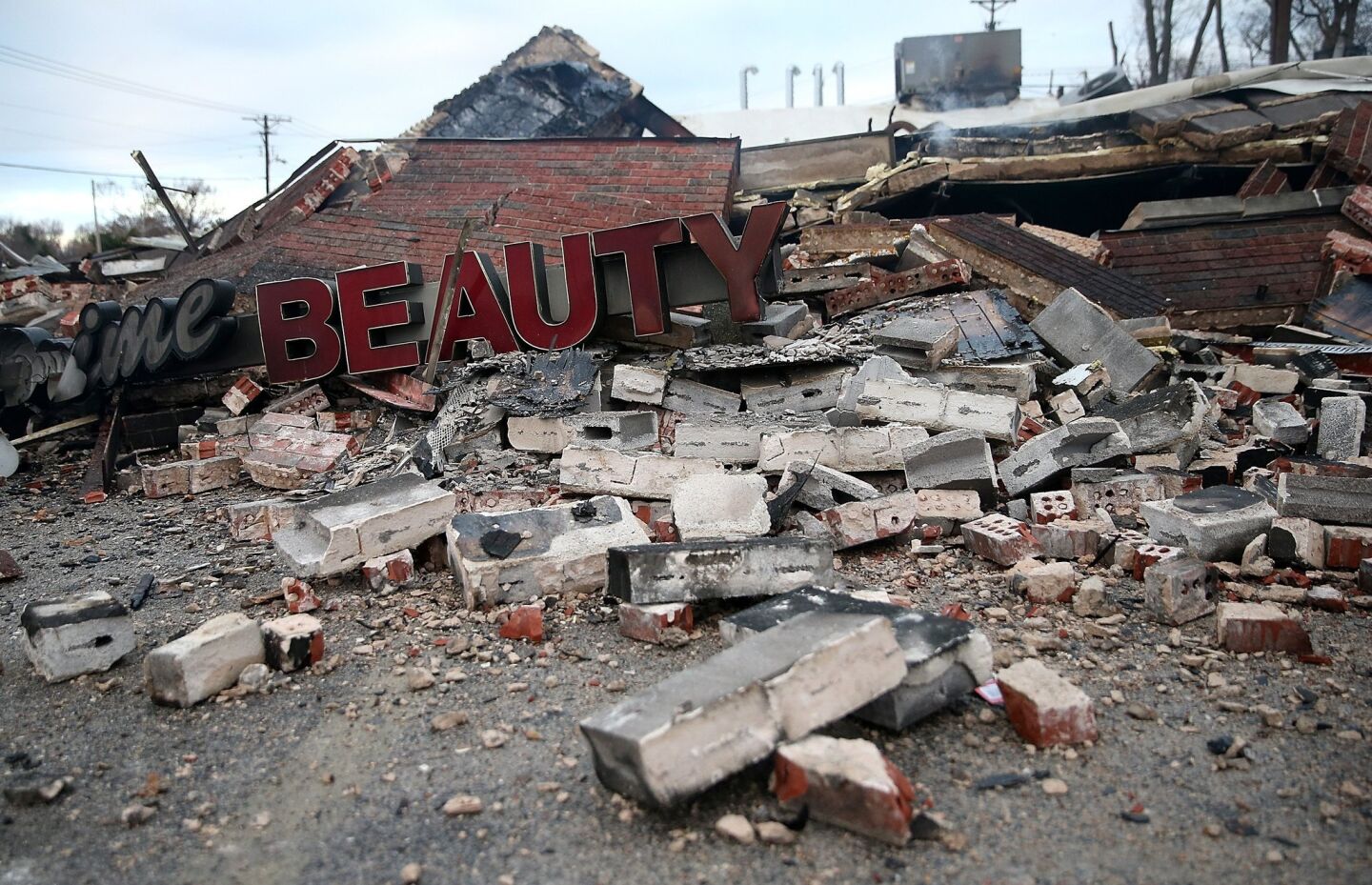A sign sits amid the rubble of a building damaged during a demonstration in Dellwood, Mo.