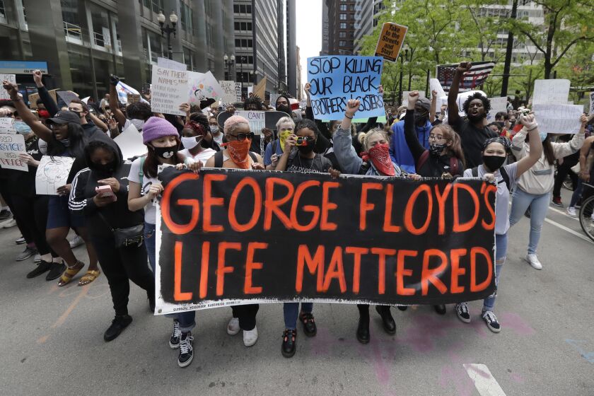 FILE - Protesters hold signs as they march during a protest over the death of George Floyd in Chicago, May 30, 2020. Candid, a leading philanthropy research group, is leading a coalition of funders and grantees that want to standardize the collection of demographic information to help target donations to minority-led groups. Corporations and foundations pledged billions for racial equity after the police killing of Floyd in 2020. But statistics show that philanthropic money flows unequally to white-led and minority-led organizations. (AP Photo/Nam Y. Huh, File)
