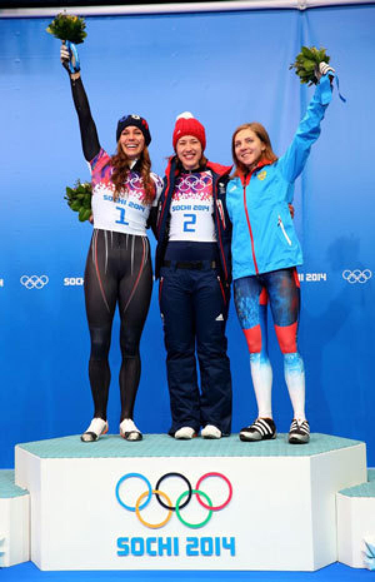 Silver medalist Noelle Pikus-Pace of the United States, gold medalist Lizzy Yarnold of Great Britain and bronze medalist Elena Nikitina of Russia celebrate after the women's skeleton.