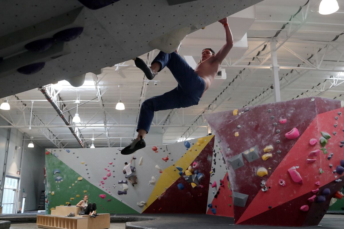 Keaton Lewis, 23, climbs a roof wall at Movement in Fountain Valley on Wednesday. 