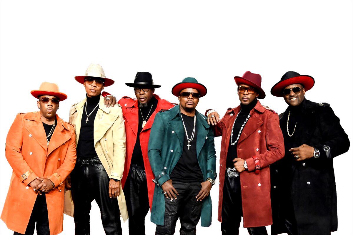 Six men in duster-length coats, hats and sunglasses