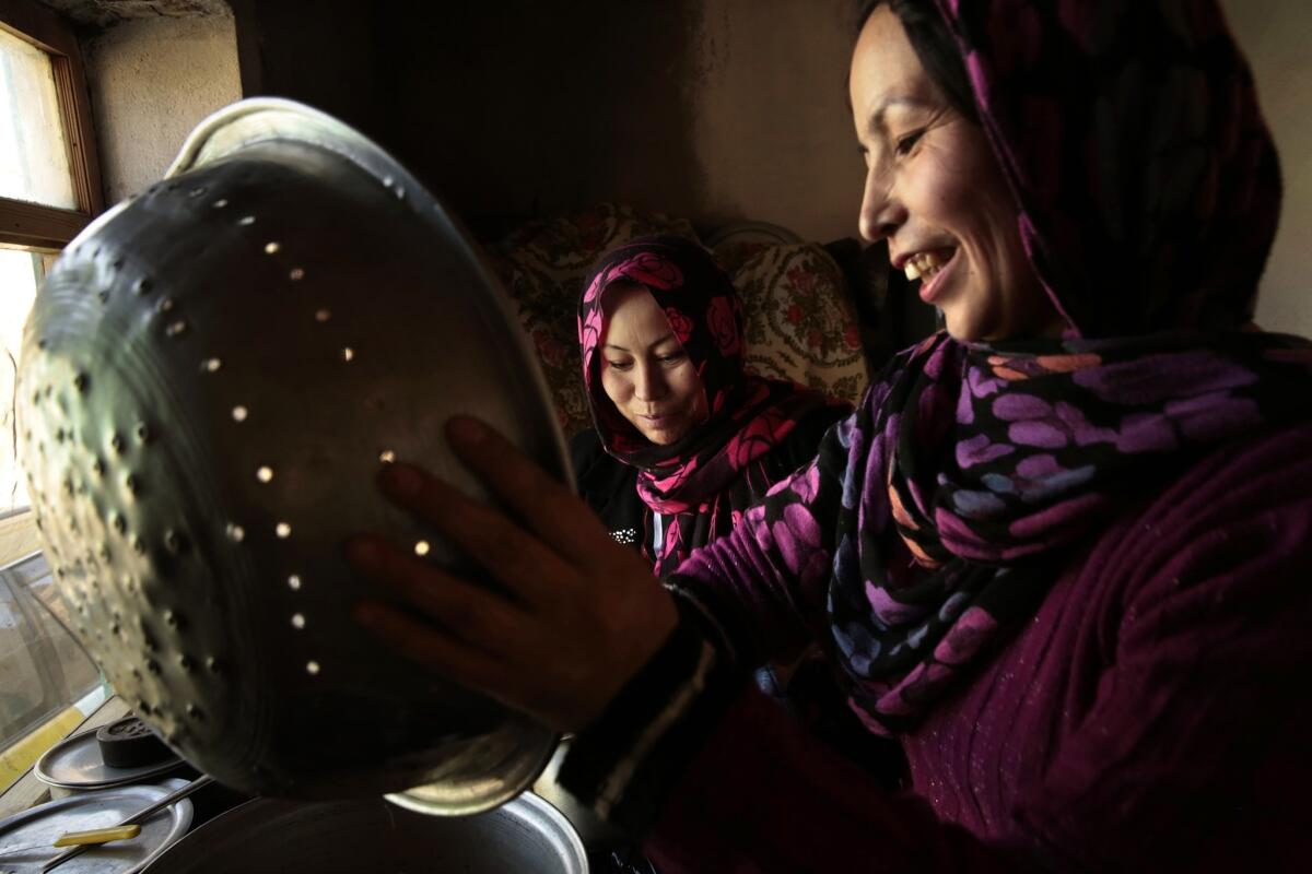 Shukriya Matin, 28, right, and her sister Fatima, 25, cook lunch for their family in Kabul.