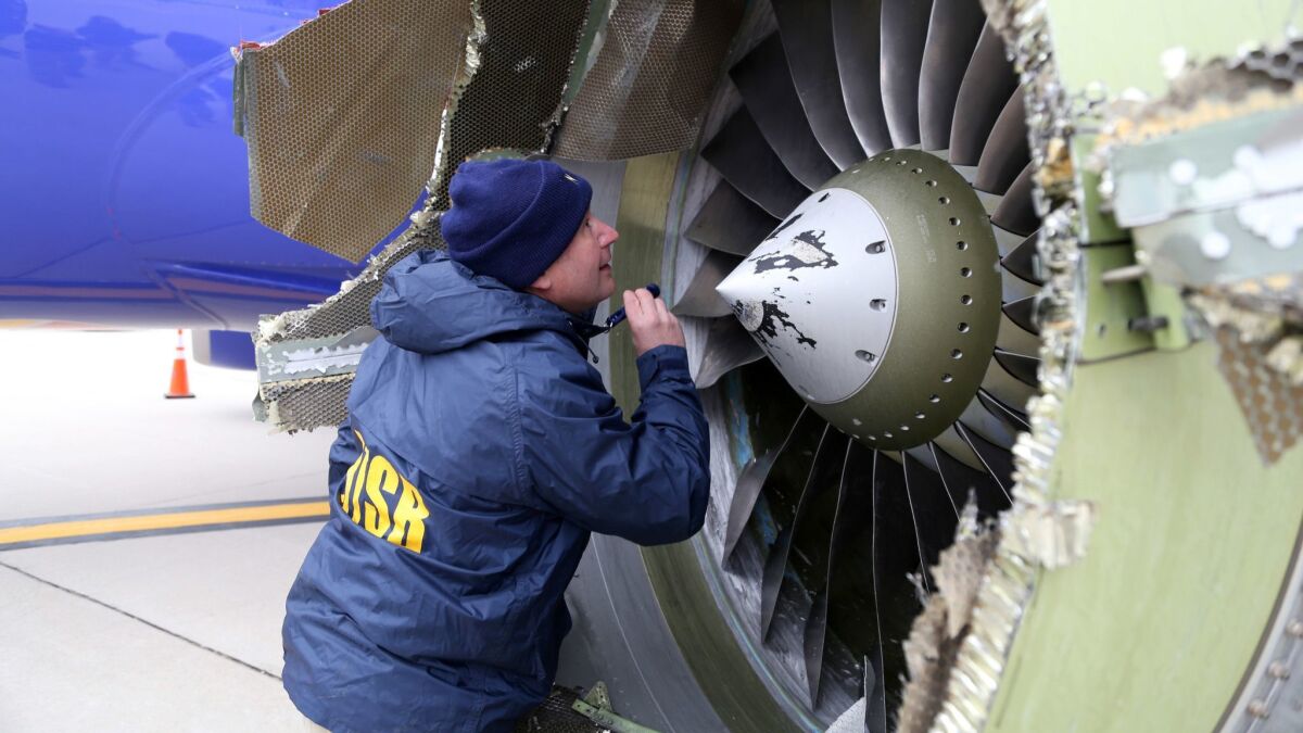 A National Transportation Safety Board investigator examines damage to the CFM engine belonging to Southwest Airlines Flight 1380.