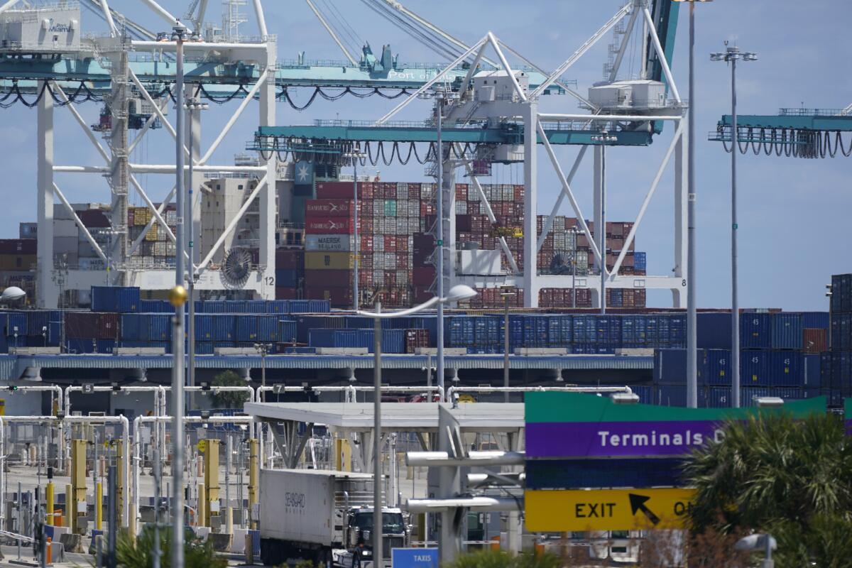 In this April 9, 2021 photo, cargo containers are shown stacked near cranes at PortMiami in Miami. The U.S. trade deficit narrowed slightly to $70.1 billion in July as economic recovery overseas helped boost American exports while imports declined. The Commerce Department reported Thursday, Sept. 2, that the trade deficit fell 4.3% in July after surging to $73.2 billion in June. (AP Photo/Wilfredo Lee)