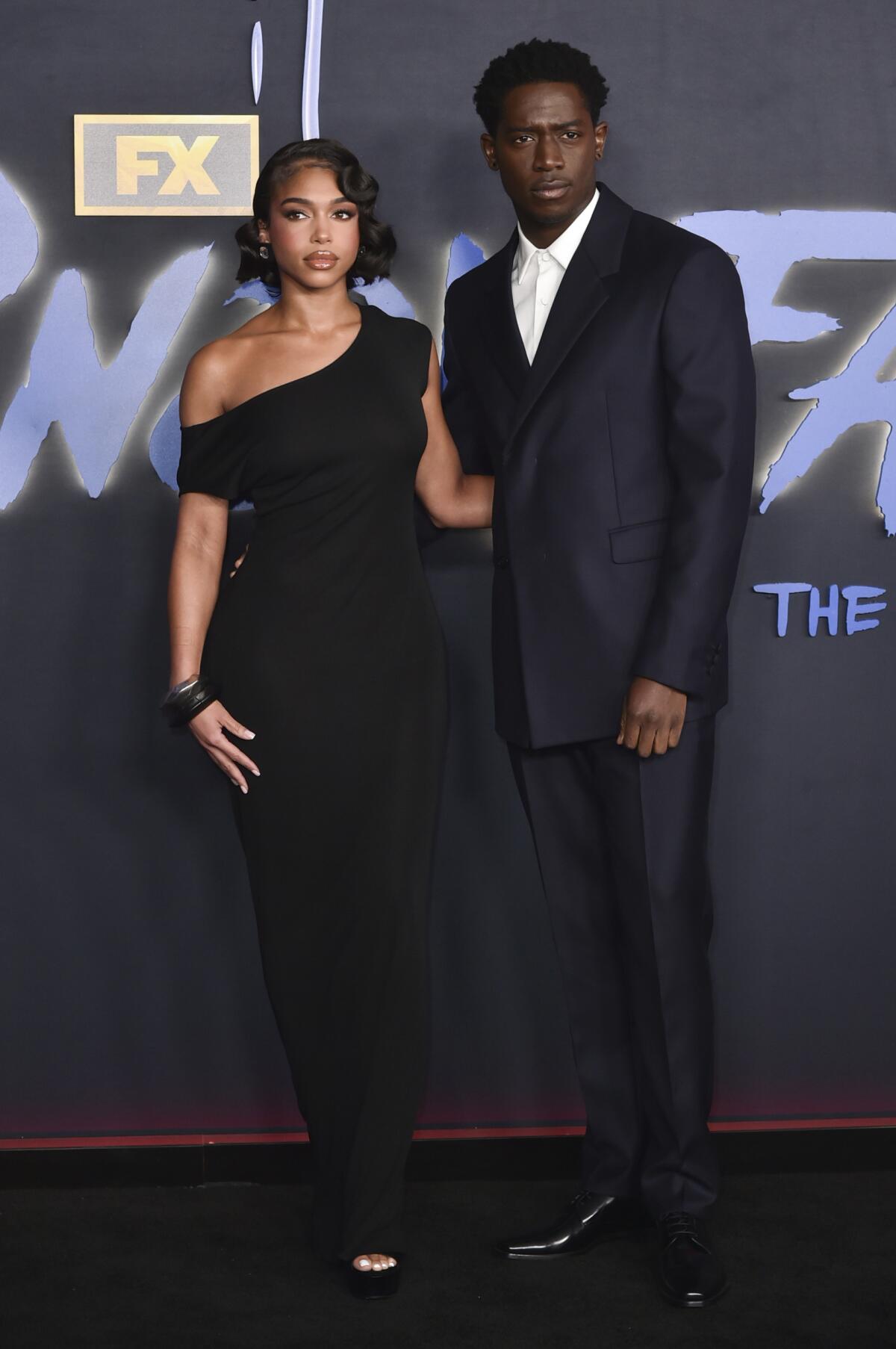 Lori Harvey, left, wears a black dress and Damson Idris wears a black blazer and pants with a white collared shirt 