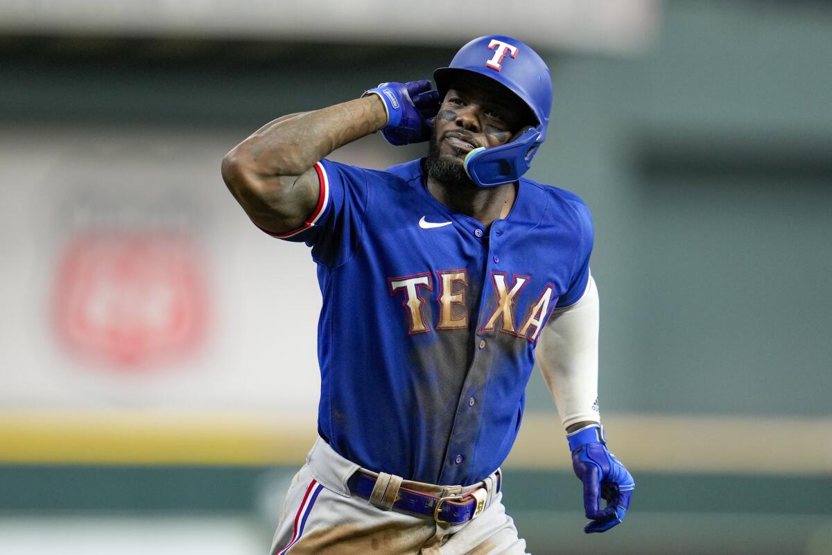 Texas Rangers' Adolis Garcia reacts after hitting a home run.